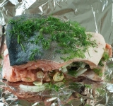 Полученной смесью фаршируем рыбку, если кусочек цельный, тогда посыпаем сверху. Сбрызгиваем рыбку и фольгу маслом и аккуратно упаковываем горбушу. Лучше использовать фольгу в два слоя.