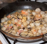 Морепродукты (можно брать любые) укладываем на сковородку, немного прожариваем и сливаем воду, добавляем приправ по вкусу, немного лука и обжариваем его вместе с морепродуктами. Готовые морепродукты переносим в бульон. К концу готовки добавляем кубики семги, душистый перец, лавровый лист, соль и перец по вкусу.