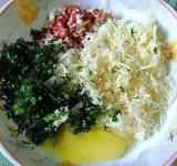 Готовим начинку, для этого сыр трем на мелкой терке, чеснок зелень мелко режим, затем перетираем их в кашицу. Колбасу (мясо, ветчину) трем на крупную терку, добавляем желток и все хорошо перемешиваем.