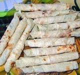 Сворачиваем лаваш в рулеты, смазав поверхность без начинки взбитым белком, чтобы рулеты при жарке не раскручивались.