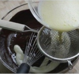 Хорошо взбиваем шоколадную массу. Процеживаем в массу 1/3 взбитых желтков. Взбиваем до однородности, таким же образом добавляем и остальные желтки.	