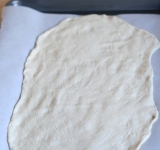 Когда тесто подошло, берем половину теста и раскатываем его в тонкий пласт 25 на 40 см.