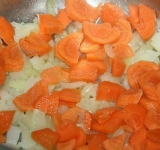 Лук измельчаем, морковь нарезаем круглешками и пассируем их в небольшом количестве масла на среднем огне 10 минут, до прозрачности лука.