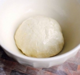 Готовим тесто, для этого перемешиваем воду, дрожжи и чайную ложку сахара. В массу добавляем соль, оливковое масло и муку, вымешиваем тесто 15-20 минут. Перекладываем массу в миску, накрываем полотенцем и оставляем на час полтора.