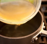 В это время готовим соус. В кастрюлю выливаем куриный бульон.	