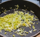 Лук мелко нарежьте и обжарьте на сковороде на сливочном масле.	