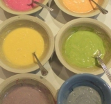 Растопленное сливочное масло взбиваем с сахаром и растительным маслом, вбиваем желтки, вновь хорошо взбиваем массу. Добавляем ваниль, молоко, йогурт, чередуя с мукой, разрыхрителем и содой. Тесто хорошо перемешиваем, разливаем по 6 формам и в каждую добавляем приготовленный краситель, чтобы получилось 6 разных коржей: свекольный сок, морковный сок, желток с 1 ст. ложкой молока, сок шпината, черничный сок, сок ежевики.