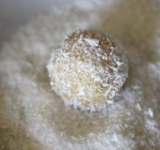 Немного мочим шарики водой, чтобы стружка лучше прилипала и обваливаем в кокосовой стружке.