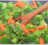 В сковороде нагреваем масло, пропускаем через пресс чеснок и убавляем огонь до минимума. Выкладываем на сковороду овощи и, аккуратно перемешивая, обжариваем 2-3 минуты.