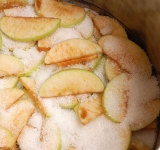 Нарезаем яблоки на небольшие дольки по 5-10 мм толщиной. Нарезанные яблоки взвешиваем и укладываем слоями в кастрюлю с сахаром в пропорции 1 к 1.