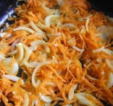 Натираем морковь на крупной терке, лук нарезаем полукольцами и обжариваем овощи на среднем огне, практически до готовности.