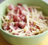 На крупной терке трем сыр и добавляем к ветчине, начинку перемешиваем.