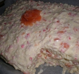 Затем выкладываем третий слой булки, чуть смазываем соусом, выкладываем кусочки рыбы и крабовых палочек и все разравниваем ложкой. Украшаем торт кусочком красной рыбы, по желанию можно зеленью.