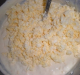 Добавляем мелко размятые вилкой яйца и хорошенько перемешиваем, с булки срезаем корки.