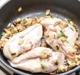 В сковороду добавьте курицу, слегка обжарьте с двух сторон, накройте бумагой для выпекания (вырежьте круг по размеру сковороды), накройте крышкой и поставьте в духовку на 12-14 минут до готовности курицы.	