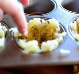 Разогреваем духовку до 200 градусов. В емкости для маффинов выкладываем по 2 ст. ложки тертого картофеля и формируем корзинки.