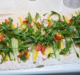 Нарежьте огурец и перец соломкой. Помидоры на небольшие дольки. Выложите на лаваш огурец, помидор, перец и зелень (я использовал рукколу).	