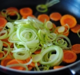 Добавляем измельченный лук и прожариваем овощи до размягчения.