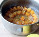 Согласно пропорции в кастрюлю выкладываем 200 г корок, засыпаем 300 г сахара и заливаем 400 мл воды. По желанию можно добавить имбирь. Варим варенье до легкого загустения, сироп должен быть похож на очень жидкий мед. Лимонную кислоту добавляем перед самым снятием с огня.