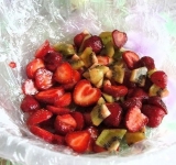 Глубокую посуду выстилаем пищевой пленкой, на дно выкладываем кусочки фруктов.