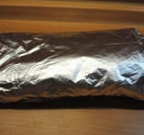 Заворачиваем рыбу в первый лист лаваша, затем переворачиваем и заворачиваем во второй лист, лаваш со всех сторон должен хорошо прикрывать рыбу. Затем заворачиваем рыбу в лаваше в фольгу.