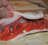 Затем выкладываем дольки помидора.