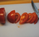 Рыбу чистим, удаляем голову, плавники, внутренности. Солим, перчим и добавляем специи по вкусу. Нарезаем помидоры полукольцами.