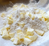 Добавляем сливочное масло, а затем растираем его с сухими ингредиентами до грубой крошки.	