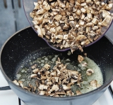 Пока варится суп, обжарьте на сковороде на среднем огне на сливочном масле порезанные шапочки грибов около 6-7 минут. Перед жаркой посолите грибы (1 щепотка) и добавьте лимонный сок.	