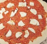 На тесто выложите томатный соус (рецепт также легко найти у нас на сайте) и кусочки сыра моцарелла. Посолите и поперчите. 
Поставьте противень в духовку на 12 минут. Перед подачей на тесто выложите листья базилика.  
Приятного аппетита!	