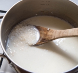 Затем добавьте горячее молоко (около 500 мл), соль и сахар и готовьте около 20 минут минут. Не забывайте иногда перемешивать, чтобы рис не подгорел.	