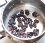 Изюм положите в кастрюльку, залейте вино. Поставьте на слабый огонь, чтобы жидкость испарилась. Либо можно просто замочить изюм в горячей воде или зеленом чае на 5 минут, а потом слить жидкость.	