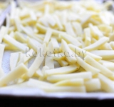 Картофель моем, чистим и нарезаем соломкой. Затем соломку выкладываем в большую миску и заливаем холодной водой, и даем воде впитаться в течение 2-3 часов.