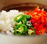 Затем добавляем в суп нарезанные кубиками лук, красный сладкий перец, мелко измельченный чеснок и перец чили.