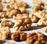 Грецкие орехи выложите на противень одним слоем и поставьте в духовку на 5 минут, затем перемешайте и поставьте еще на 5 минут. Остудите и порубите.	