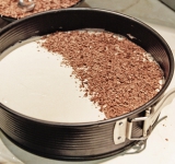 Начинаем собирать торт. Советую один корж положить в форму для торта (чтобы легче и удобнее было). Корж намажьте получившимся кремом, затем посыпьте натертым черным шоколадом (да, его надо натереть), сверху положите корж и повторите все тоже самое. Верхний корж намажьте кремом, посыпьте какао и тертым сыром. 
Остается дать торту пропитаться (около 4 часов). Это наверно самое сложное. И торт готов. Наслаждайтесь!	