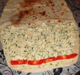 Намазываем лаваш приготовленной начинкой, сверху выкладываем ломтики помидора.