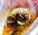 Готовим маринад, для этого в большом полиэтиленовом пакете перемешиваем апельсиновый сок, сок двух лаймов, раздавленный чеснок, тмин, красный перец, орегано и порезанный полукольцами лук.