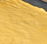 Достаем тесто и раскатываем в пласт по размеру противня. Выкладываем тесто на застланный пергаментной бумагой противень.