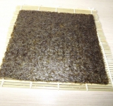 Для удобства расстилаем бамбуковую салфетку (макису), поверх выкладываем лист водорослей.