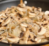 Добавляем к луку грибы и курицу, обжариваем ингредиенты еще 5-8 минут.