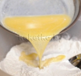 Выливаем смесь молока в тесто и с помощью резинового шпателя перемешиваем массу до равномерности.