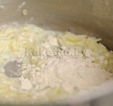 Когда лук готов, добавляем ложку муки, все хорошо перемешиваем и добавляем оставшееся молоко. Увеличиваем огонь.