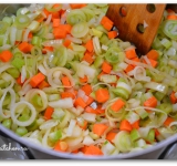 Кастрюлю ставим на средний огонь, наливаем растительное масло, кладем на дно морковь, сельдерей, лук-порей и репчатый лук. Хорошо перемешиваем и тушим 5 минут. Добавляем картошку, перемешиваем и тушим еще 5 минут. Следим, чтобы ничего не подгорело.