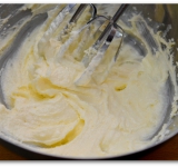 При помощи миксера взбиваем сахар и масло до легкой, воздушной массы. Добавляем желтки, снова взбиваем массу.	