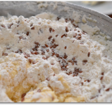 Просеиваем сухие ингредиенты в масляно-творожную смесь. Добавляем семена льна. Хорошо вымешиваем массу вилкой.