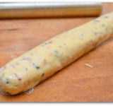 Высыпаем эту массу в приготовленное тесто и вымешиваем до однородности. Скатываем тесто в ровную трубочку диаметром примерно 4 см. Обматываем трубочку пищевой пленкой и убираем в холодильник на 2 часа.	