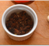 На несколько минут заливаем изюм кипятком.