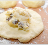 Каждый шарик раскатываем в лепешку, в центр лепешки выкладываем начинку.