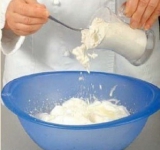 К желткам добавляем треть взбитых белков. Всыпаем муку и слегка перемешиваем. Затем добавляем оставшиеся белки и аккуратными движениями перемешиваем массу силиконовой лопаткой с низу вверх. Должно получиться однородное тесто.	